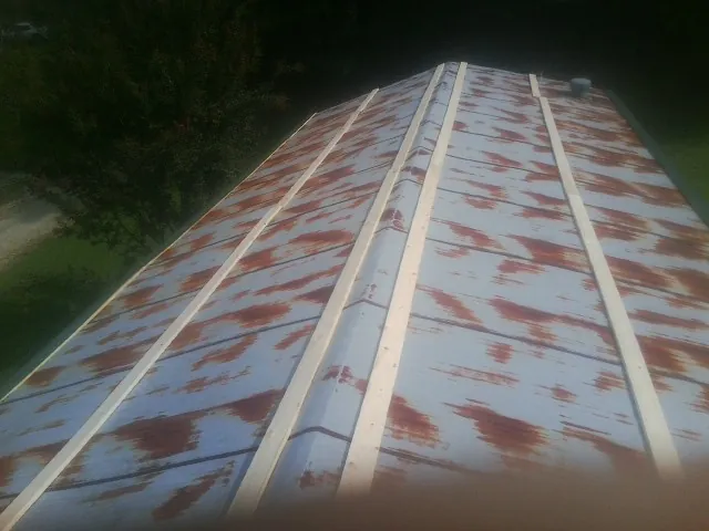 Rusted metal roof panels with new wood purlins before replacement — Storm Damage Roof Repair in Middleboro by Roofing Brothers