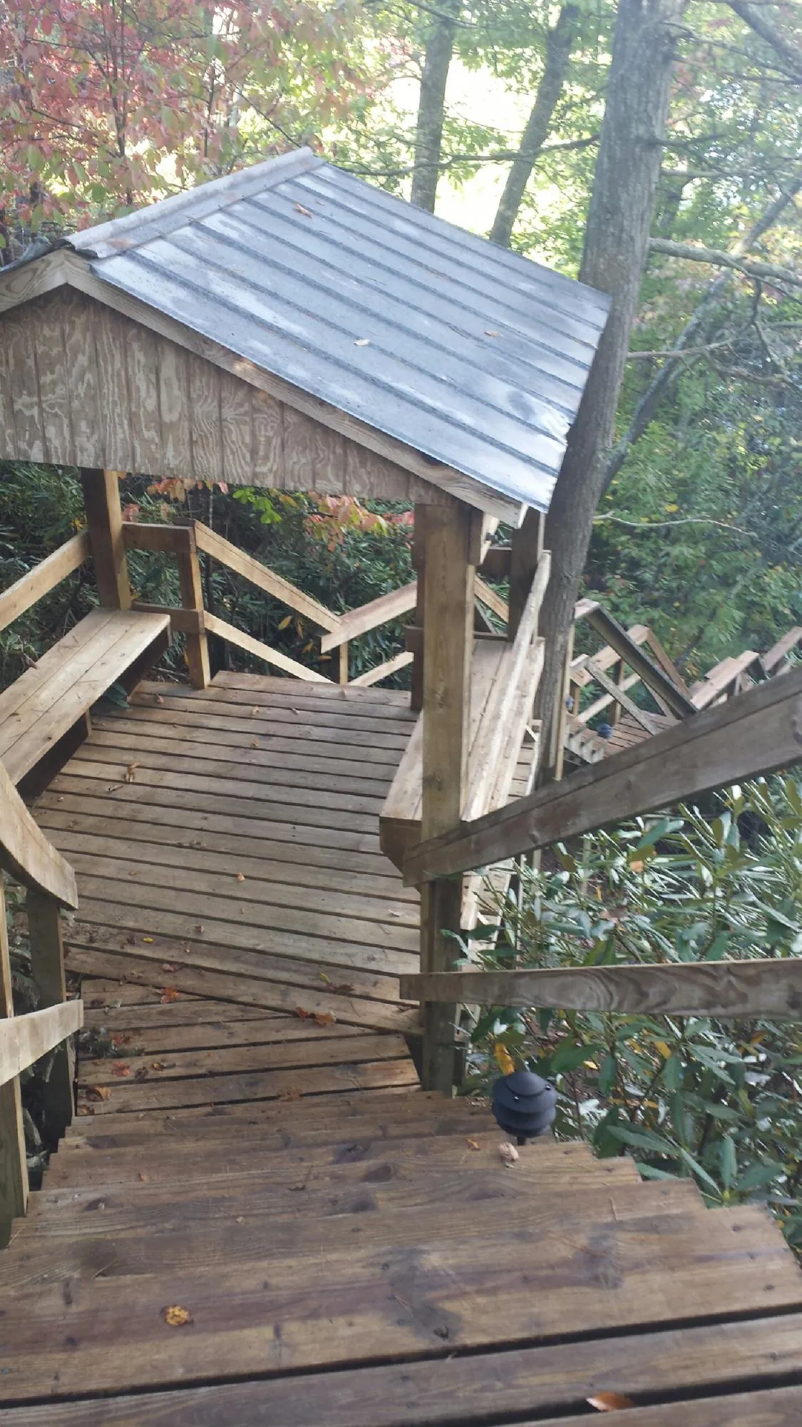 Metal roofed shelter over wooden steps on a wooded walkway — Skylight Repair & Installation work by our crew in Middleboro