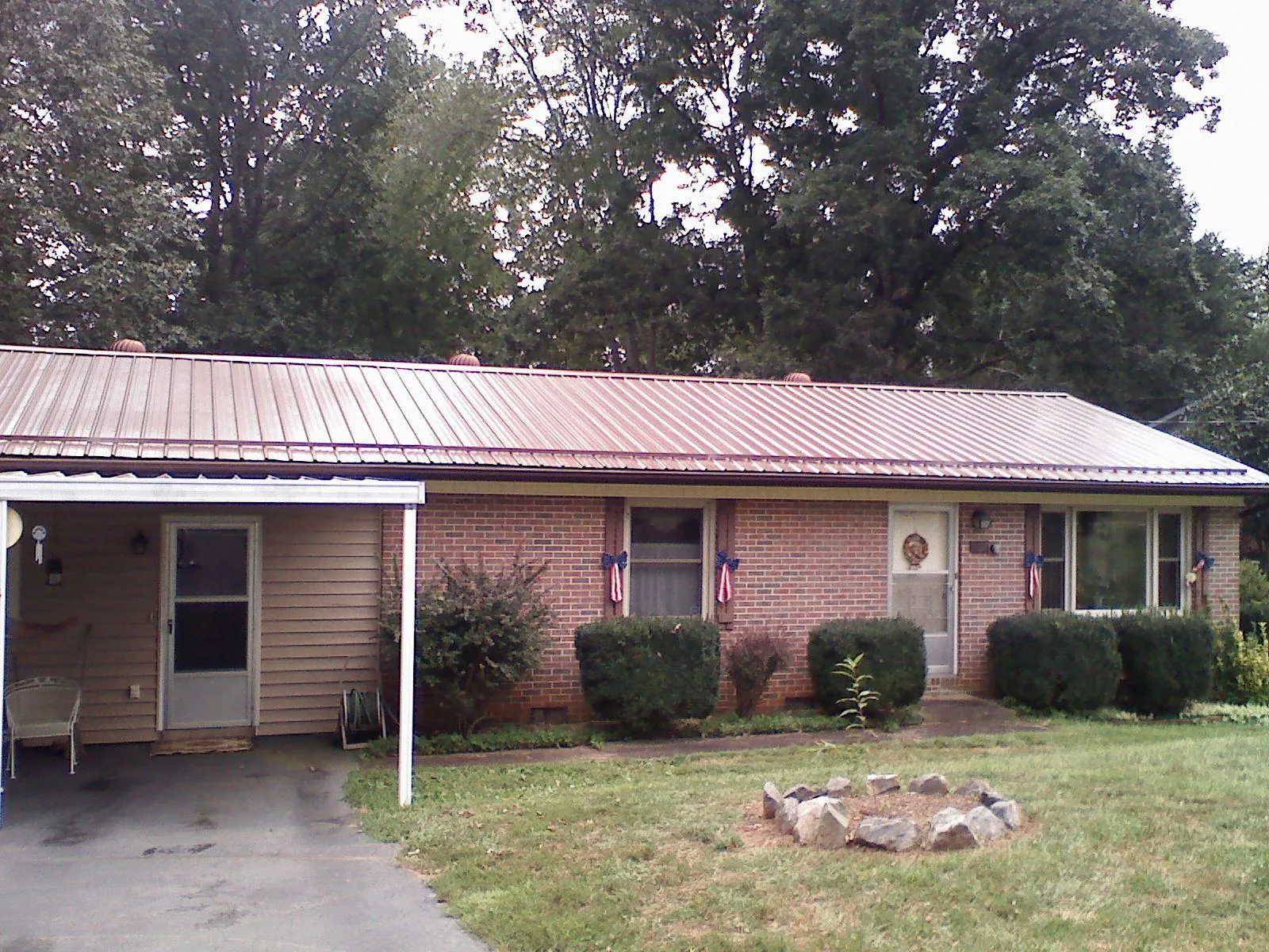Bronze metal roof and carport on a brick ranch home — Roof Repair work by our crew in Middleboro